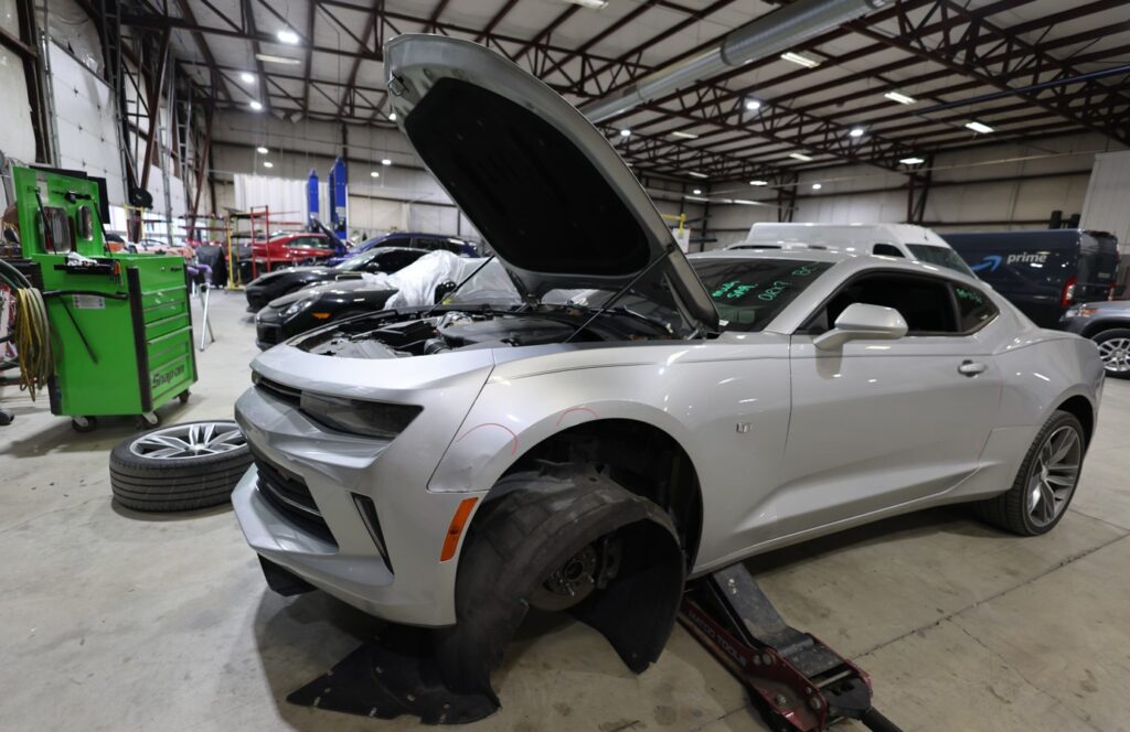 Two vehicles undergoing collision repair inside Burnside Express Collision’s West Indianapolis auto body shop.