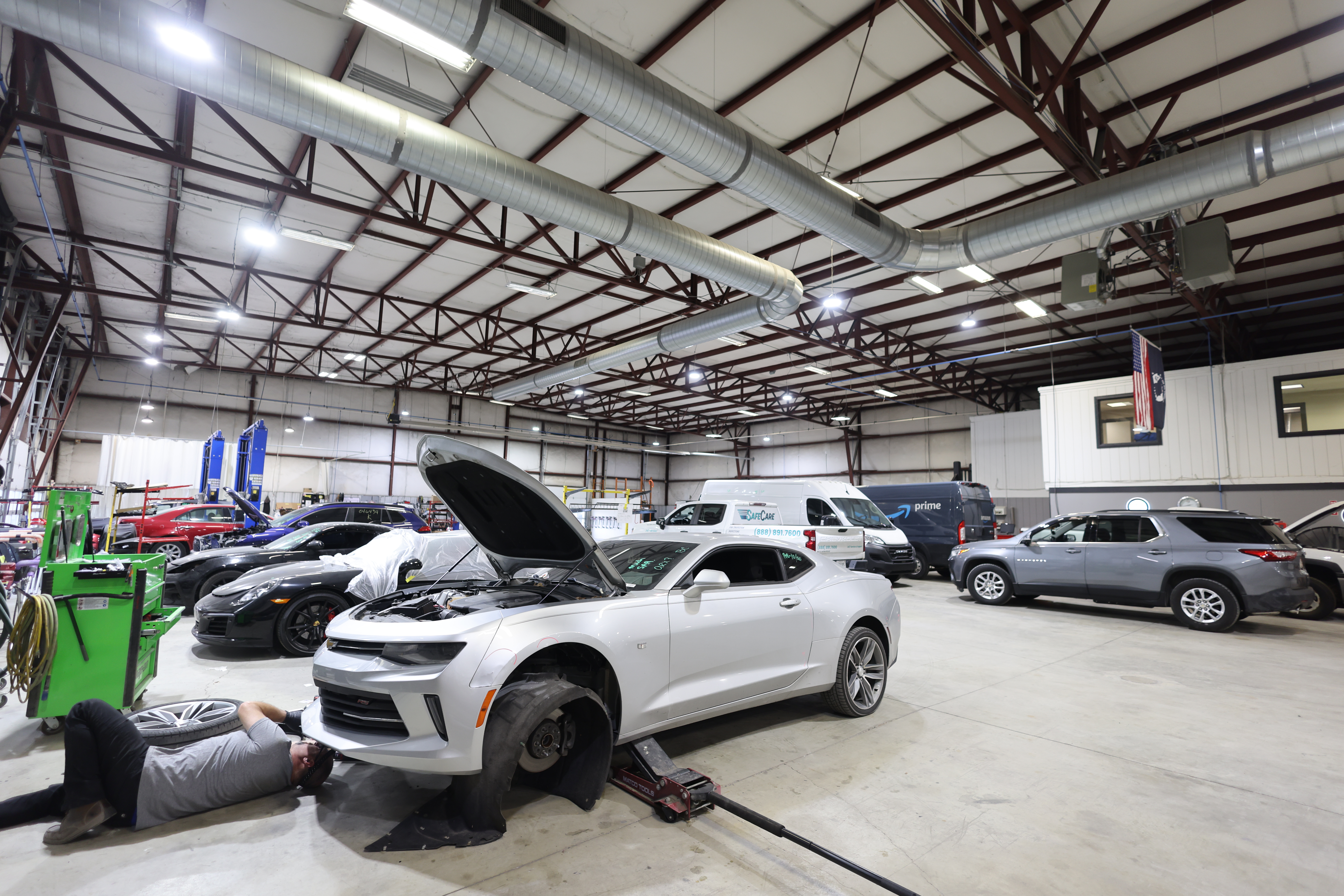 Wide view of the repair bays inside Burnside Express Collision’s West Indianapolis auto body shop with multiple vehicles undergoing collision repair.