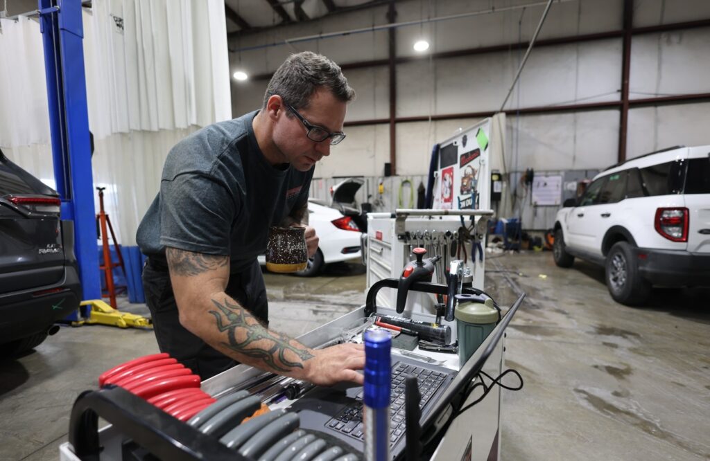 Technician working on a vehicle inside Burnside Express Collision’s West Indianapolis auto body shop.